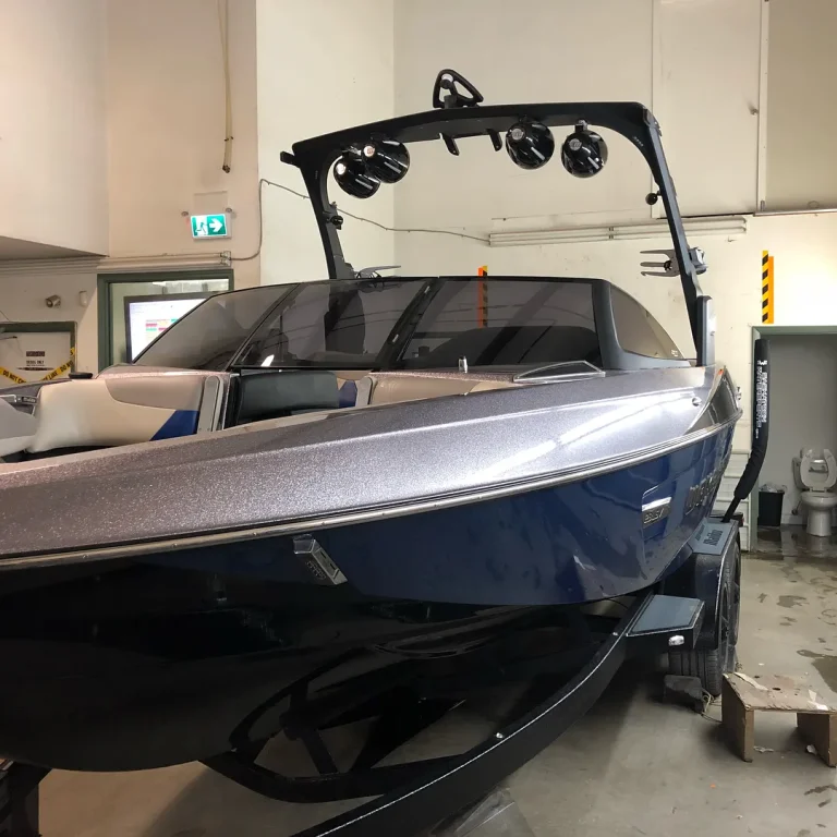 A speed boat with metallic vinyl wrap on the top.