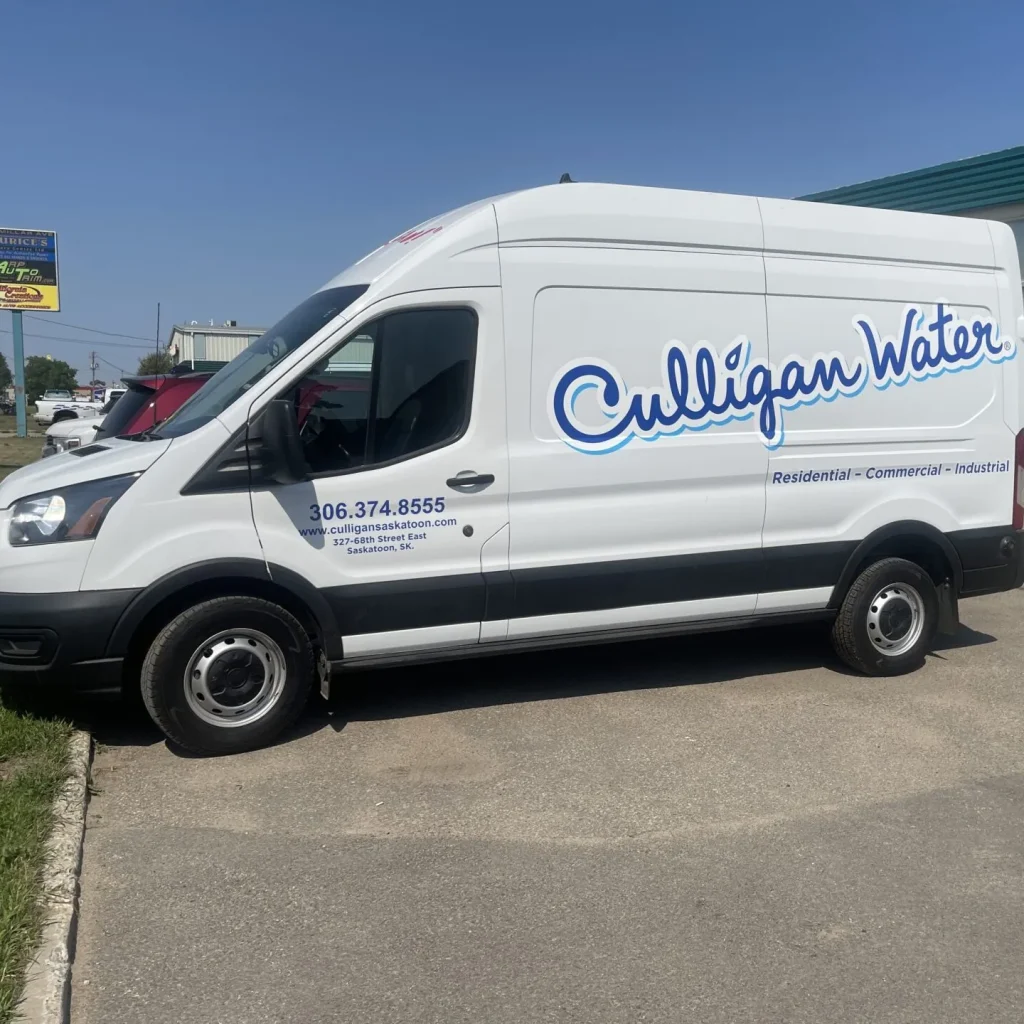 A white delivery van with custom lettering on the side