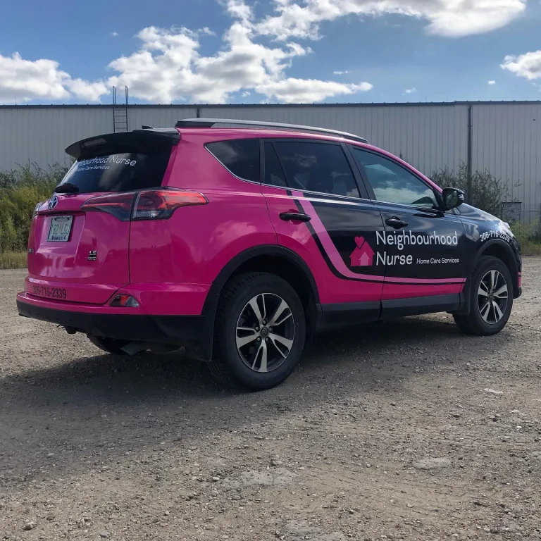 A SUV wrapped in pink graphics and company logo