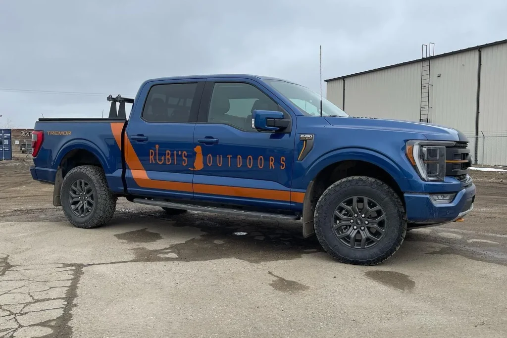 A blue pickup truck with company name and logo