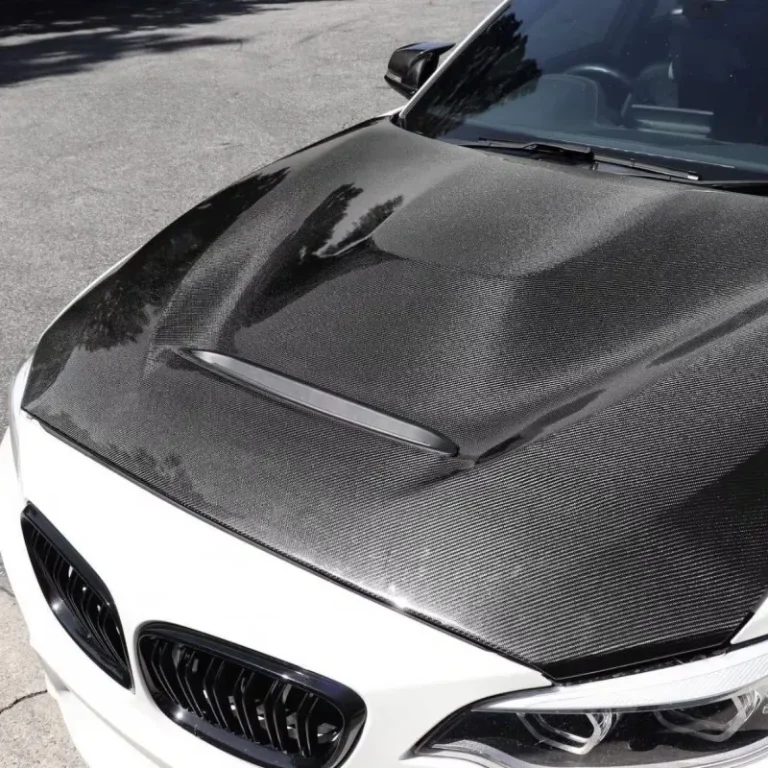 A white sportscar with black carbon fibre vinyl hood wrap.