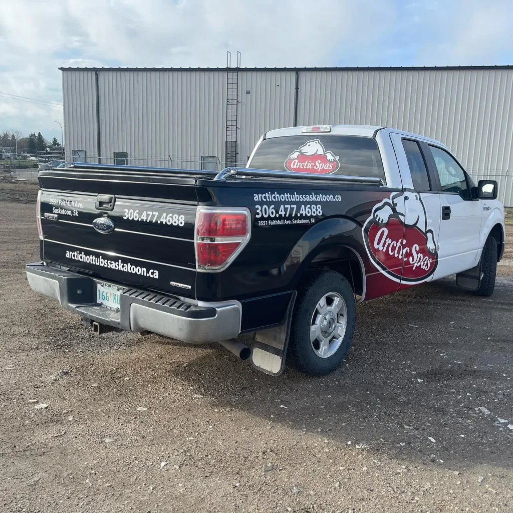 A work truck with custom graphics and logos on the side, rear and cab rear window.