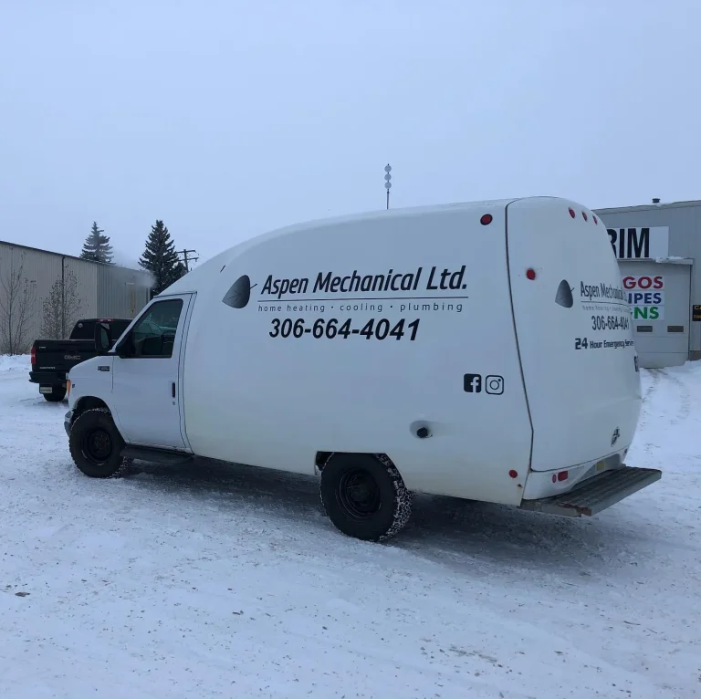 A white truck with vinyl lettering on the side and back.