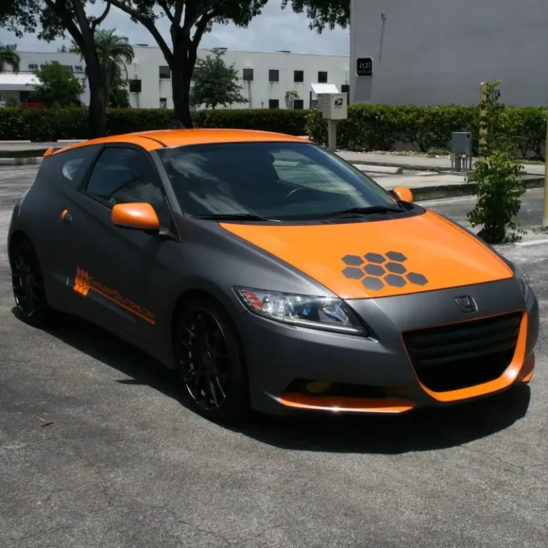 A Honda car with orange highlights and accent vinyl wrap.