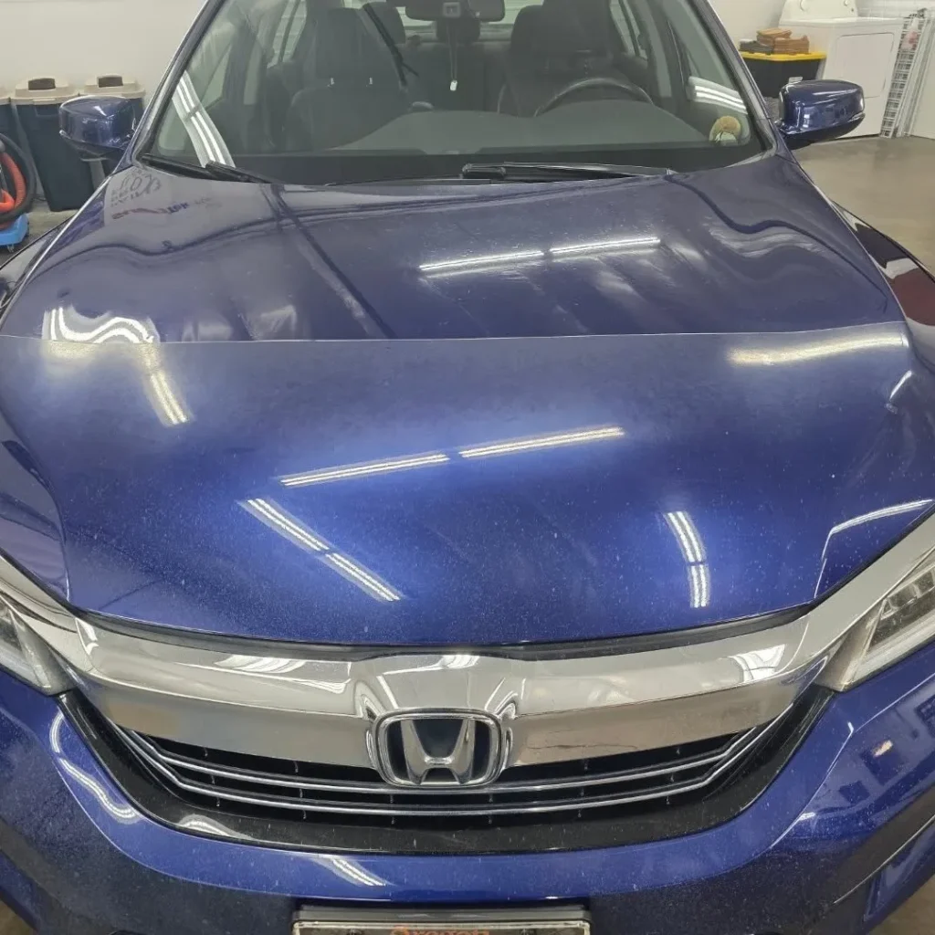 A car that has PPF on half of the hood.