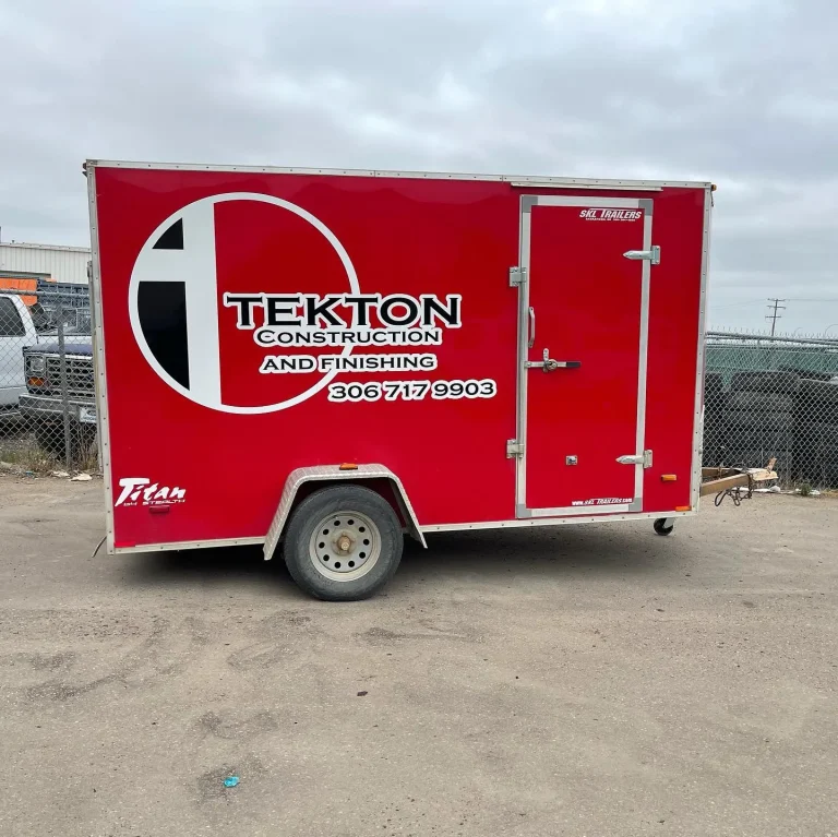 A red trailer with company logo and contact information on the side.
