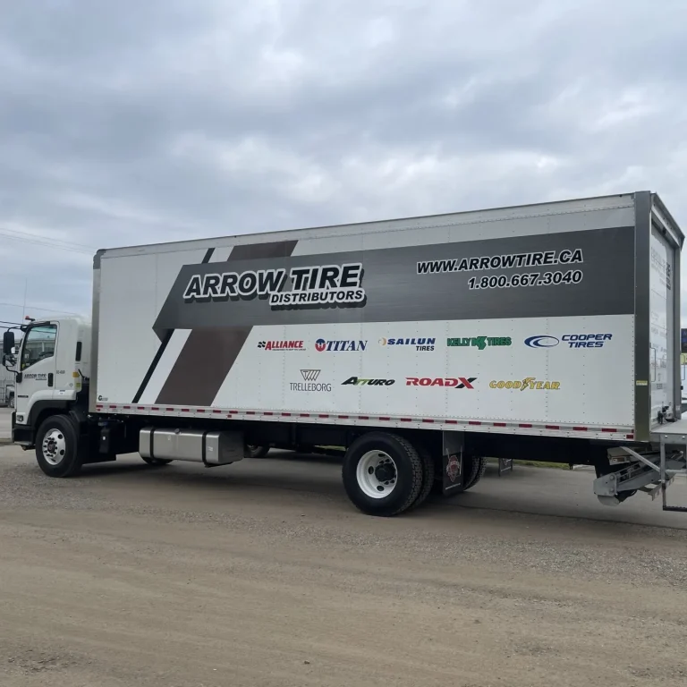 A transport truck with company logo and graphics on the side box.