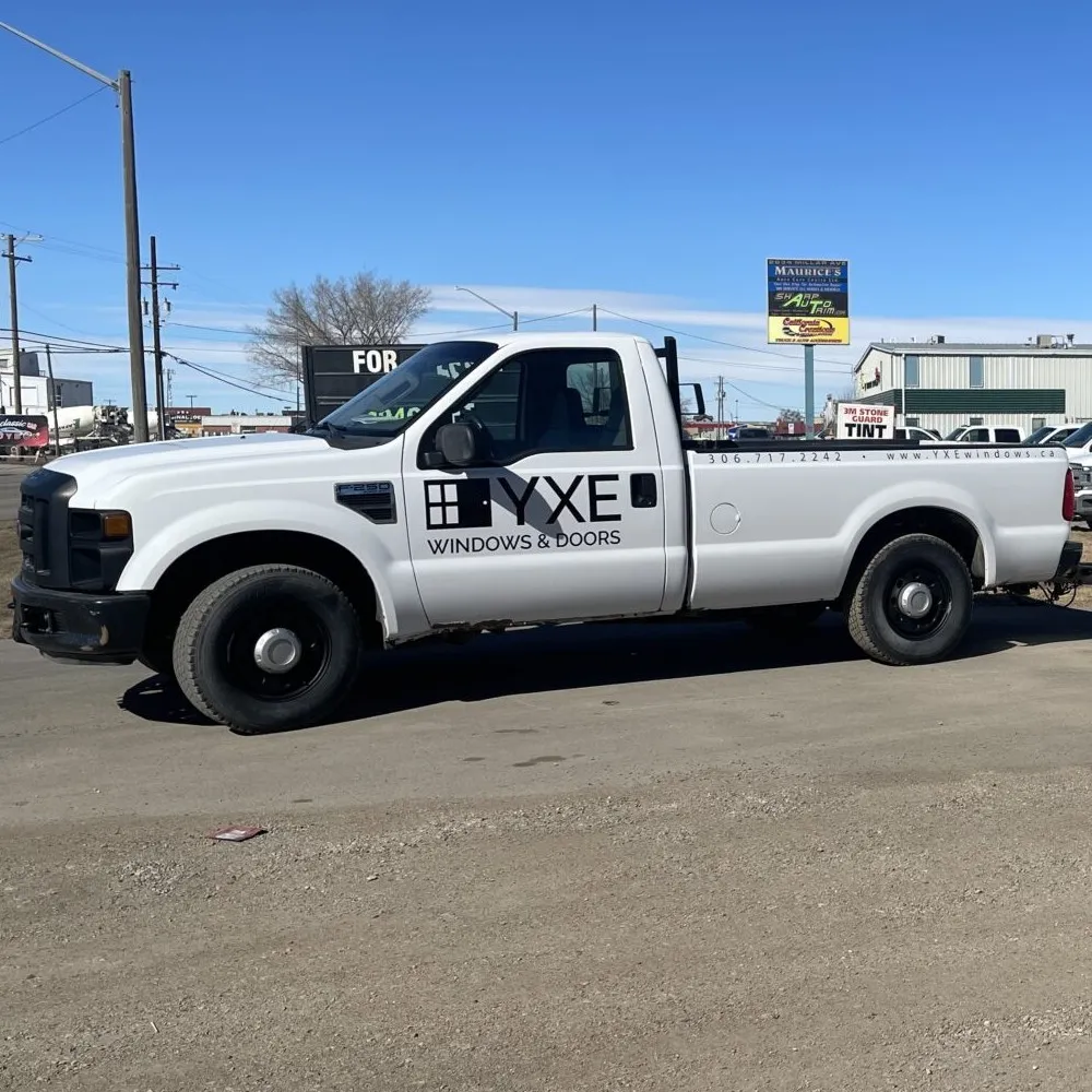 A white pickup truck with black company logo and lettering on the side door.