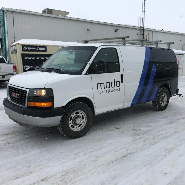 A white van with company logo on door as well as rear quarter wrapped in vinyl.