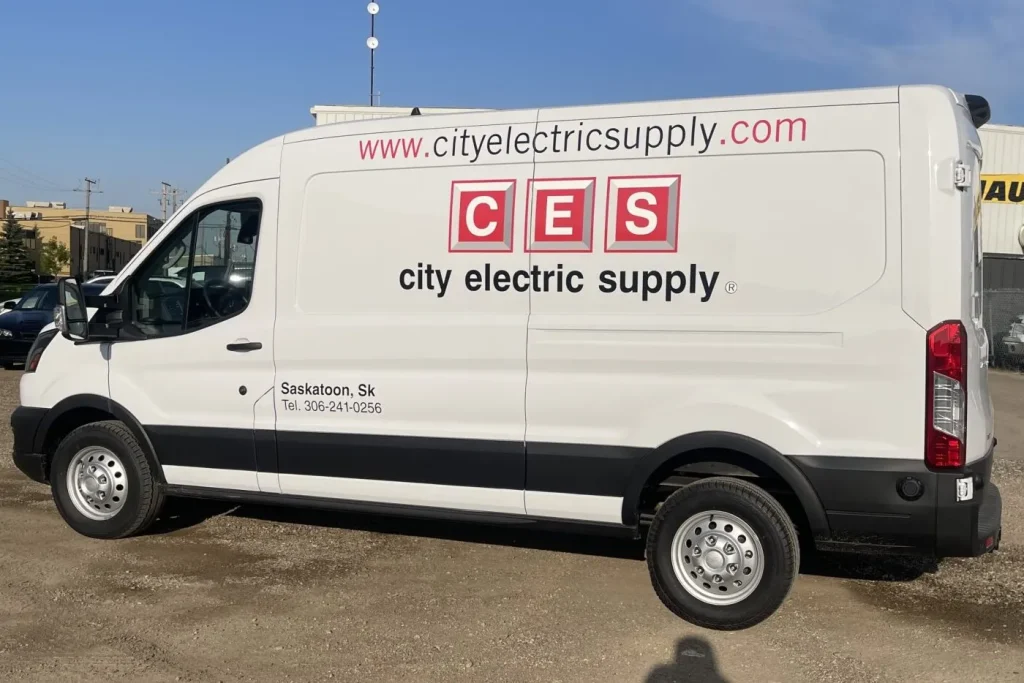 A white work van with company logo and wording on the side.