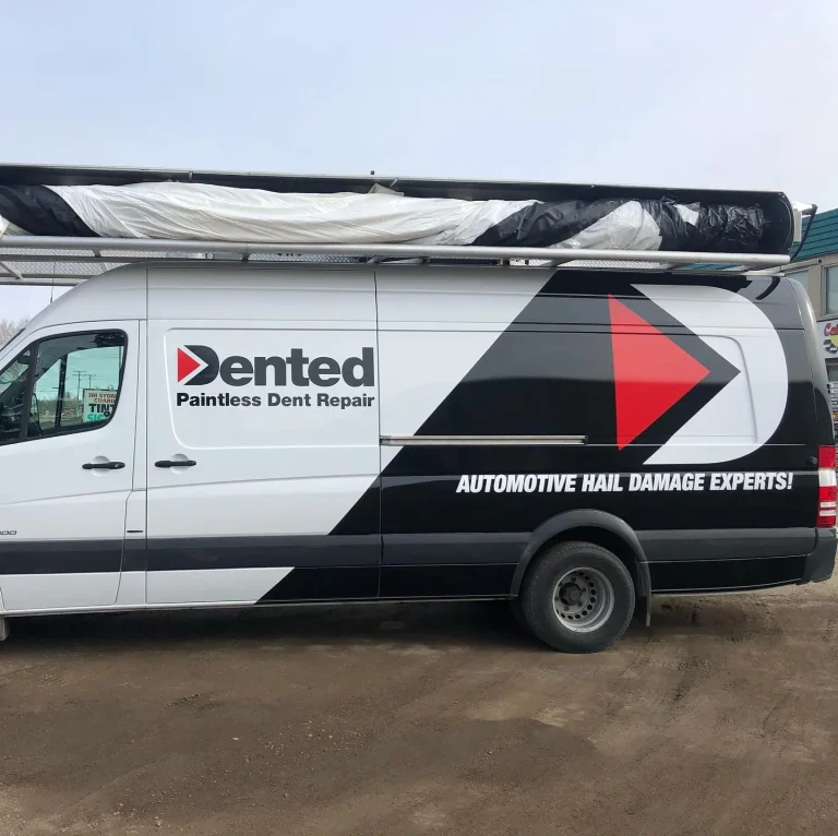 A white van with company logo on the side and rear half wrapped in vinyl graphics.